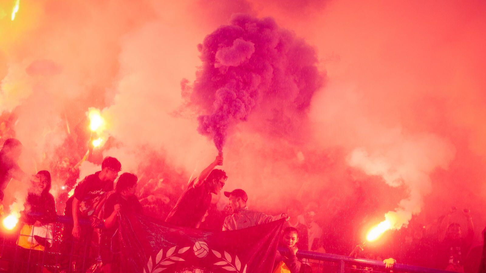 Suporter mengudarakan asap biru di tengah kepulan merah flare saat Persib Bandung merayakan juara Liga 1 2024-2025 di Stadion Gelora Bandung Lautan Api (GBLA), Bandung, 24 Mei 2025. (Yogie Gandanaya/Skor.id)