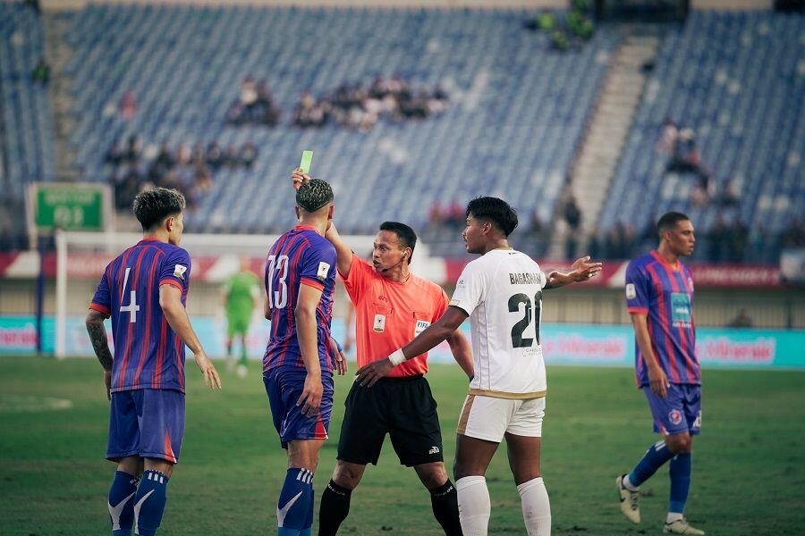 Wasit asal Malaysia, Razlan Joffri, memberikan kartu kuning kepada Suphanan Bureerat (4) dalam laga Dewa United FC (putih) vs Port FC di Stadion Si Jalak Harupat, Bandung, pada 10 Juli 2025. (Yogie Gandanaya/Skor.id)