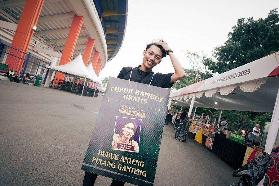 Cukur atau potong rambut gratis menjadi salah satu pengisi lapak UMKM yang disediakan di area Stadion Si Jalak Harupat, Bandung, dalam penyelenggaraan Piala Presiden 2025 pada 13 Juli 2025. (Yogie Gandanaya/Skor.id)