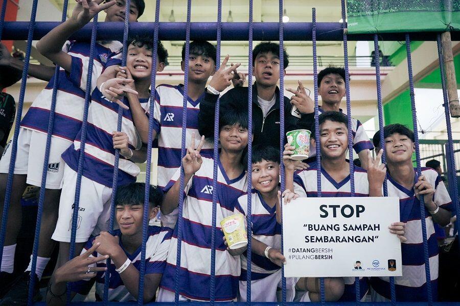 Para pesepak bola muda yang menghadiri langsung Stadion Si Jalak Harupat, Bandung, pada gelaran Piala Presiden 2025 ikut menyuarakan gerakan bersih-bersih, Juli 2025. (Yogie Gandanaya/Skor.id)