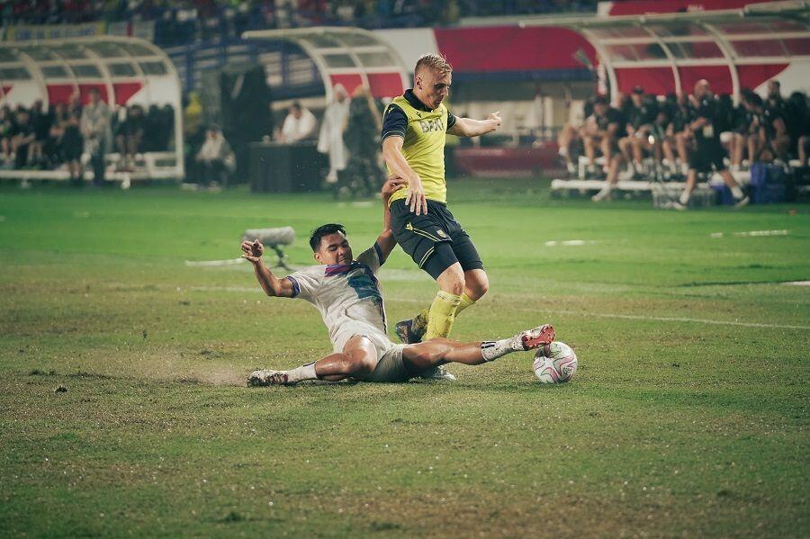 Pemain asal Indonesia, Asnawi Mangkualam, melakukan tekel bersih untuk merebut bola saat membela klub Thailand, Port FC, melawan Oxford United pada final Piala Presiden 2025 di Stadion Si Jalak Harupat, Bandung, 13 Juli 2025. (Yogie Gandanaya/Skor.id)