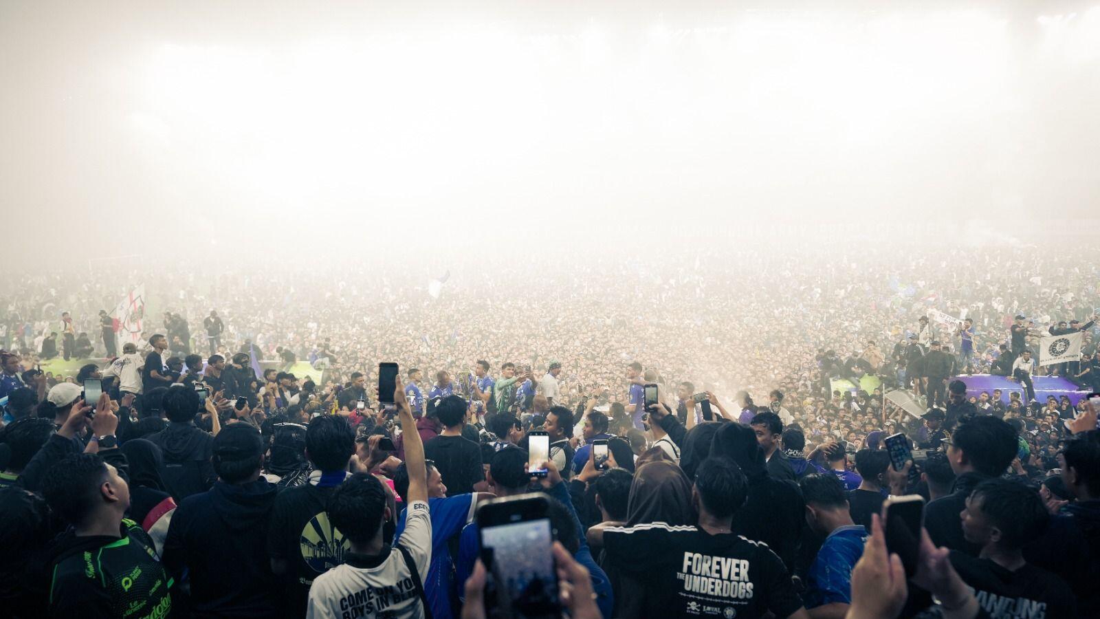 Para pemain Persib Bandung dikerubungi suporter yang turun ke lapangan Stadion Gelora Bandung Lautan Api (GBLA), Bandung, 24 Mei 2025. (Yogie Gandanaya/Skor.id)