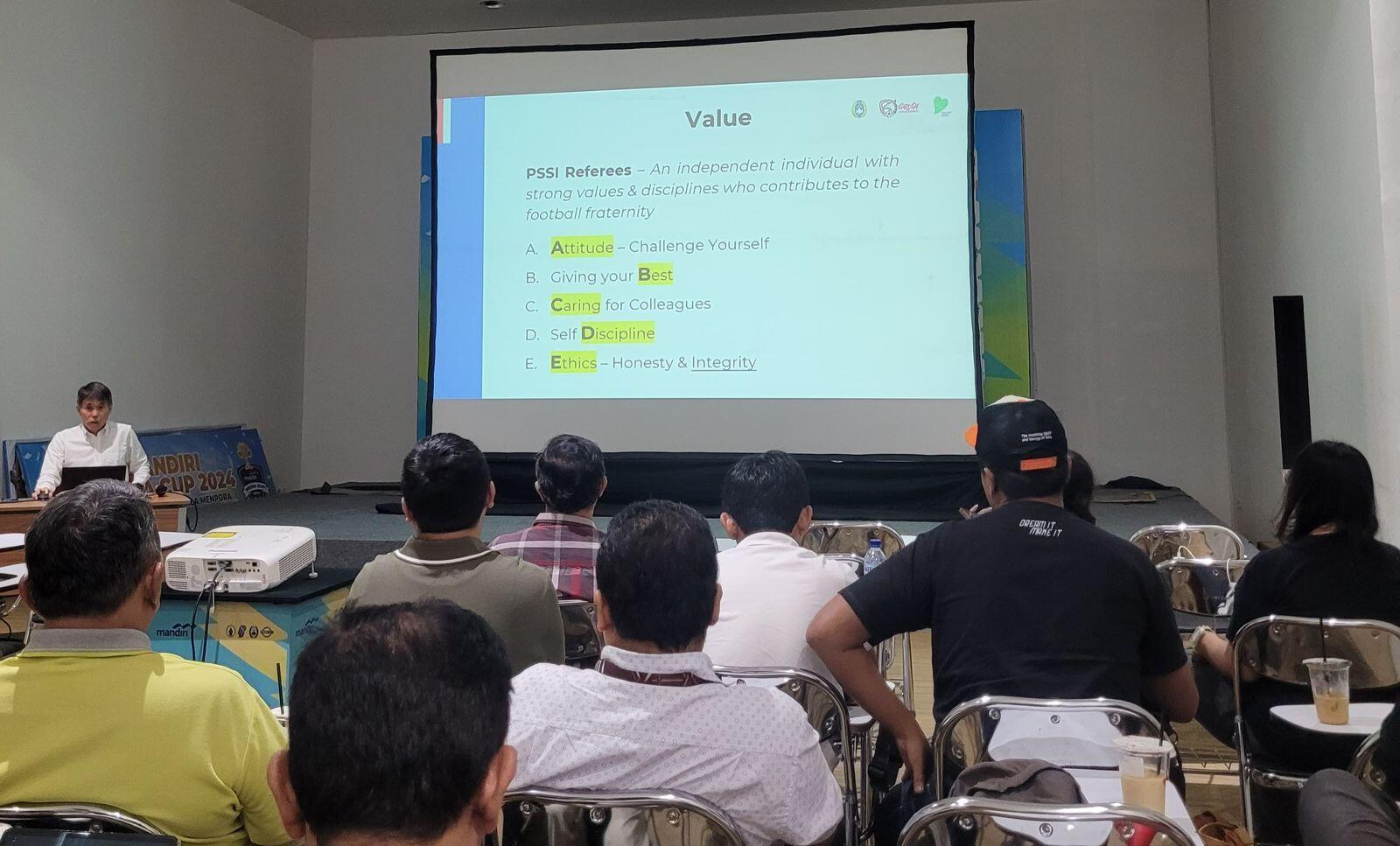 Ketua Komite Wasit PSSI, Yoshimi Ogawa (depan), memberikan materi soal wasit untuk Super League 2025-2026 kepada awak media dalam agenda Refereeing Workship for Media di Jakarta pada 6 Agustus 2025. (Yogie Gandanaya/Skor.id)