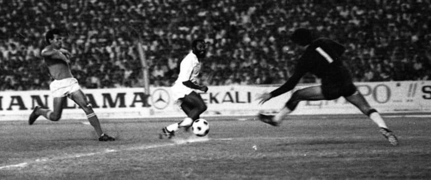 Aksi winger Santos FC, Edu (tengah) memperdaya kiper timnas Indonesia, Ronny Pasla (nomor 1) dan kapten skuad Garuda, Anwar Ujang untuk mencetak gol dalam uji coba di Stadion Utama Senayan, Jakarta Pusat pada 21 Juni 1972. 